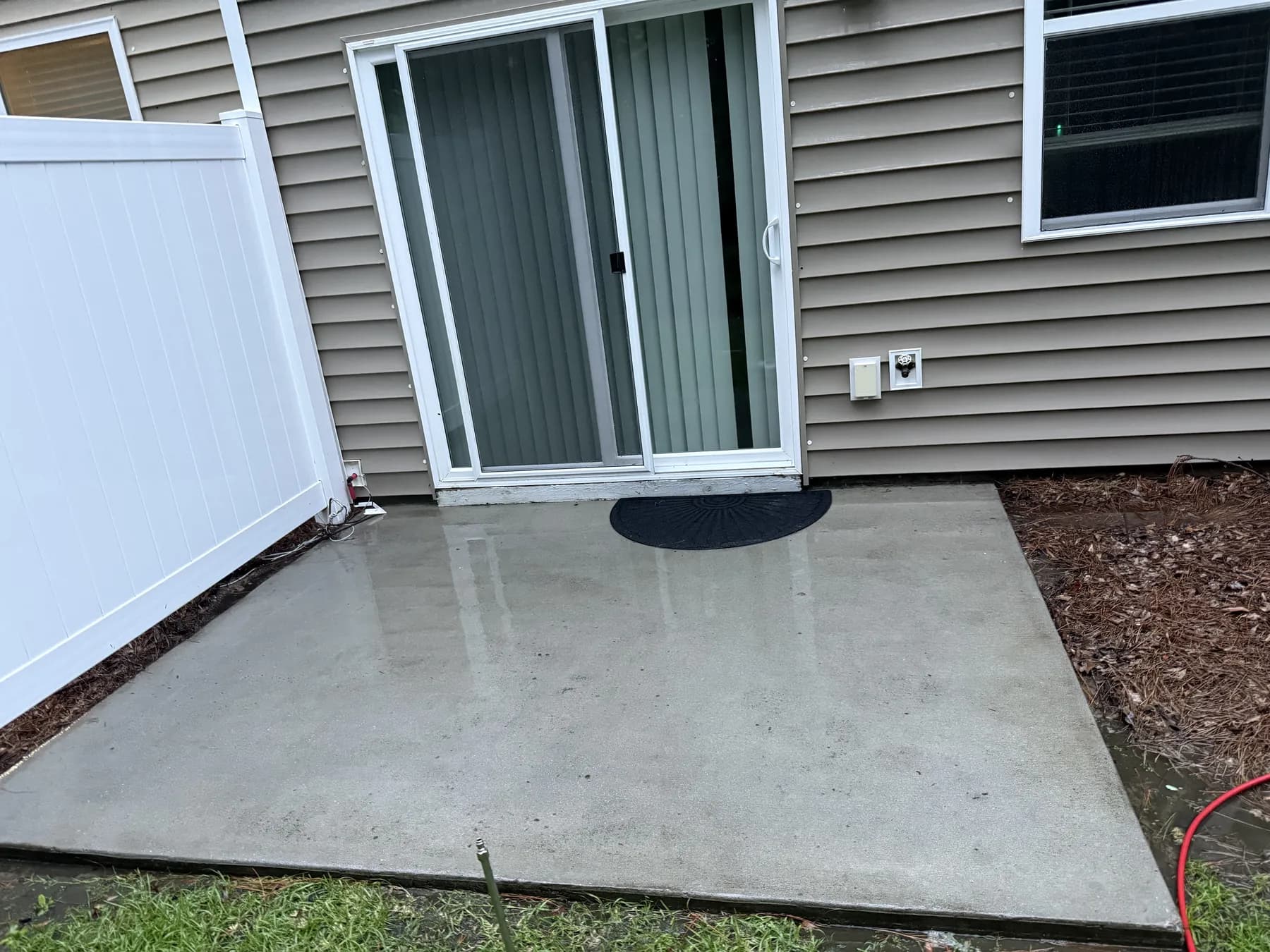 Concrete entry patio and vinyl siding before and after pressure washing by Kenny’s Pristine Detailing in Charleston SC